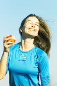Sportliche Frau frisst Apfel
