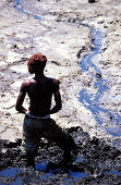 African boy digging hole, people at work