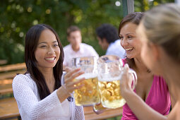 Three young women, friends, having fun in a beer garden, lake Starnberg See, Bavaria, Germany