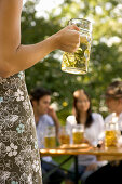 Rear view of woman holding beer stein, Munich, Bavaria