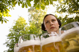 Waitress with beer steins in beer garden near Lake Starnberg, Bavaria, Germany
