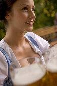 Waitress with beer steins in beer garden, Munich, Bavaria