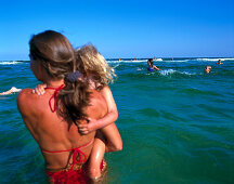 Woman standing in water, holding daughter on arms, Dueodde, Bornholm, Baltic Sea, Denmark
