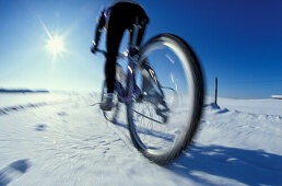 Mountainbiker fährt im Schnee, Fünf Seen Gebiet, Oberbayern, Deutschland