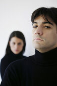 Serious man looking at camera, woman standing in background, Vienna, Austria