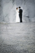 Bridal couple standing in front of a rock face