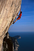 Freeclimber on rock face, No Siesta 8b, Muzzerone, Cinque Terre, Italy