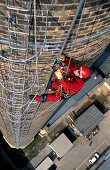 Secured worker climbing up factory chimney, Renovation works on factory , Lower Austria