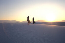Women walking over dunes, White Sands National Monument, New Mexico, USA