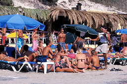 Eine Gruppe junge Leute am Strand, Sa Trincha, Platja de ses Salines, Ibiza, Spanien