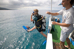 Diver jumping off the boat of Les Heures Saines Diving School, Bouillante, Basse-Terre, Guadeloupe, Caribbean Sea, America