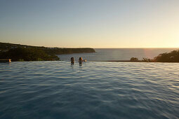 Menschen im Pool des Hotel Restaurant Le Rayon Vert im Licht der Abendsonne, Deshaies, Basse-Terre, Guadeloupe, Karibik, Amerika