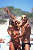 Junges Paar umarmen sich am Strand, Sa Trincha, Platja de ses Salines, Ibiza, Balearen, Spanien