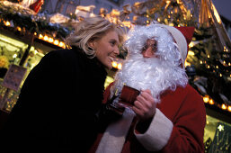 Frau mit Weihnachtsmann, auf Weihnachtsmarkt Deutschland