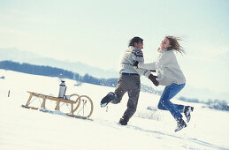 Paar tobt im Schnee, Winterlandschaft