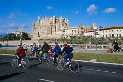 Eine Gruppe Radfahrer, Cathedral La Seu, Kathedrale der Heiligen Maria, Palma de Mallorca, Mallorca, Spain