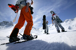 Three Snowboarder on feet, starting their ascend to Koenigsspitze near Ortler, Sulden, Italy