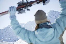 Woman holding skis, Kuehtai, Skifahrerin, Hohe Mut und Gaiskogel im Hintergrund, Kuehtai, Tyrol, Austria