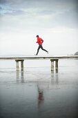 Young man running at jetty
