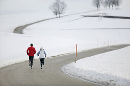 Young couple running on country road