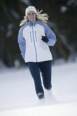 Young woman running on snow