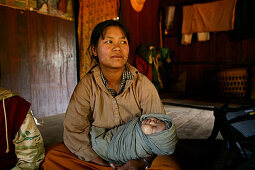 Mother sitting with baby on floor, Burma, Myanmar