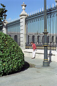Person in front of fence of Palacio Real, Madrid, Spain