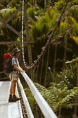 Wanderer auf einer Hängebrücke auf dem Heaphy Track, Kahurangi Nationalpark, Südinsel, Neuseeland, Ozeanien