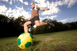 Young soccer player kicking the ball