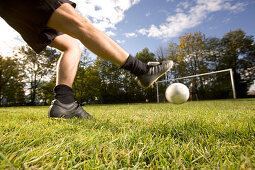 Young soccer player kicking the ball