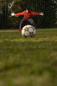 Young goalkeeper awaiting penalty, arms outstretched