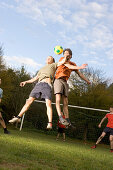 Young men playing soccer, heading the ball