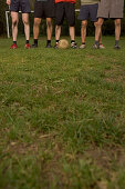 Legs of five young male soccer players, standing in a row