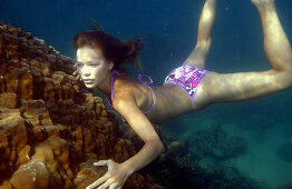Woman swimming underwater, freediving, Koh Tao, Thailand