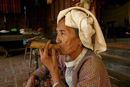 portrait of eldery woman smoking cheerot cigar, Myanmar