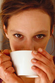 Junge Frau trinkt Cappuccino, People