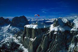 Paraglider over mountain tops, Sella Ronda, Dolomites, Alto Adige, Italy