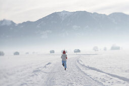Girl 5-6 Years, running on snow, rearview