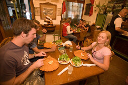 Guests eating big Wiener Schnitzel at Restaurant Figlmüller, Vienna, Austria