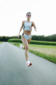 Young woman jogging on country road