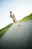 Young woman jogging on country road