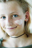 Teenage girl rubbing cream into face