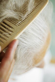 Seniorin mit weißen Haaren wird gekämmt