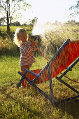 Little girl playing with garden hose