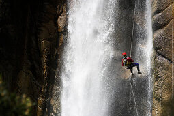 Canyoning, Ein Man seilt in einem Wasserfall ab, Piscia di Gallu, Ospedale, Mittelmeer, Korsika, Frankreich