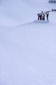 Fünf Personen halten Snowboards und Skier hoch, Kühtai, Tirol, Österreich
