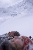 Two young woman lying on snow, Kuehtai, Tyrol, Austria