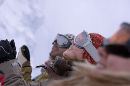 Gruppe junger Leute steht in einer Reihe an der Skipiste, Kühtai, Tirol, Österreich