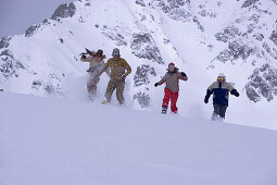 Vier Person laufen schneebedeckten Hang hinunter, Kühtai, Tirol, Österreich