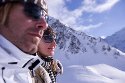 Junges Paar sitzt neben der Skipiste, Kühtai, Tirol, Österreich